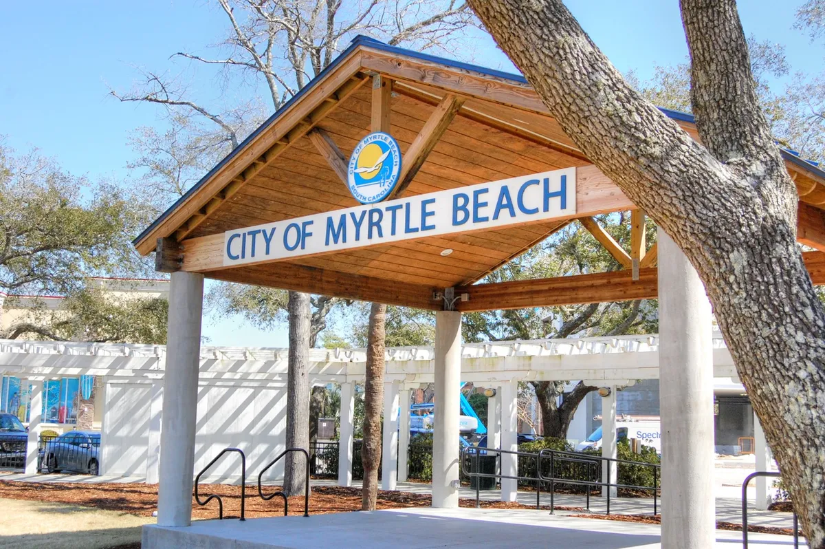 An inviting pavilion structure marked with the 'City of Myrtle Beach' sign, surrounded by trees, suggesting a hub for community events and gatherings.